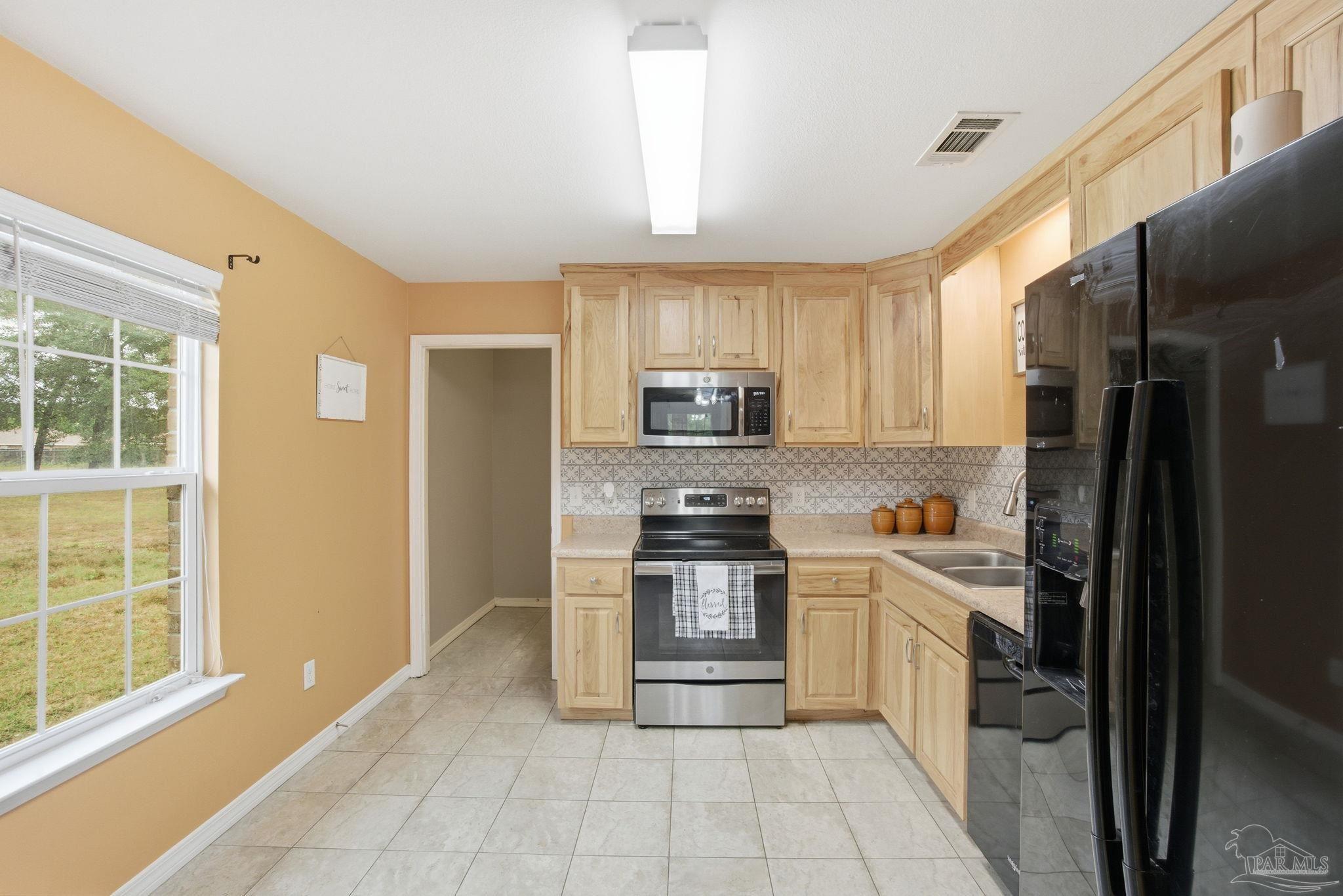 4393 Rice Road Milton, FL 32583 - Photo 11 of 52 a kitchen with stainless steel appliances granite countertop a refrigerator and a stove top oven