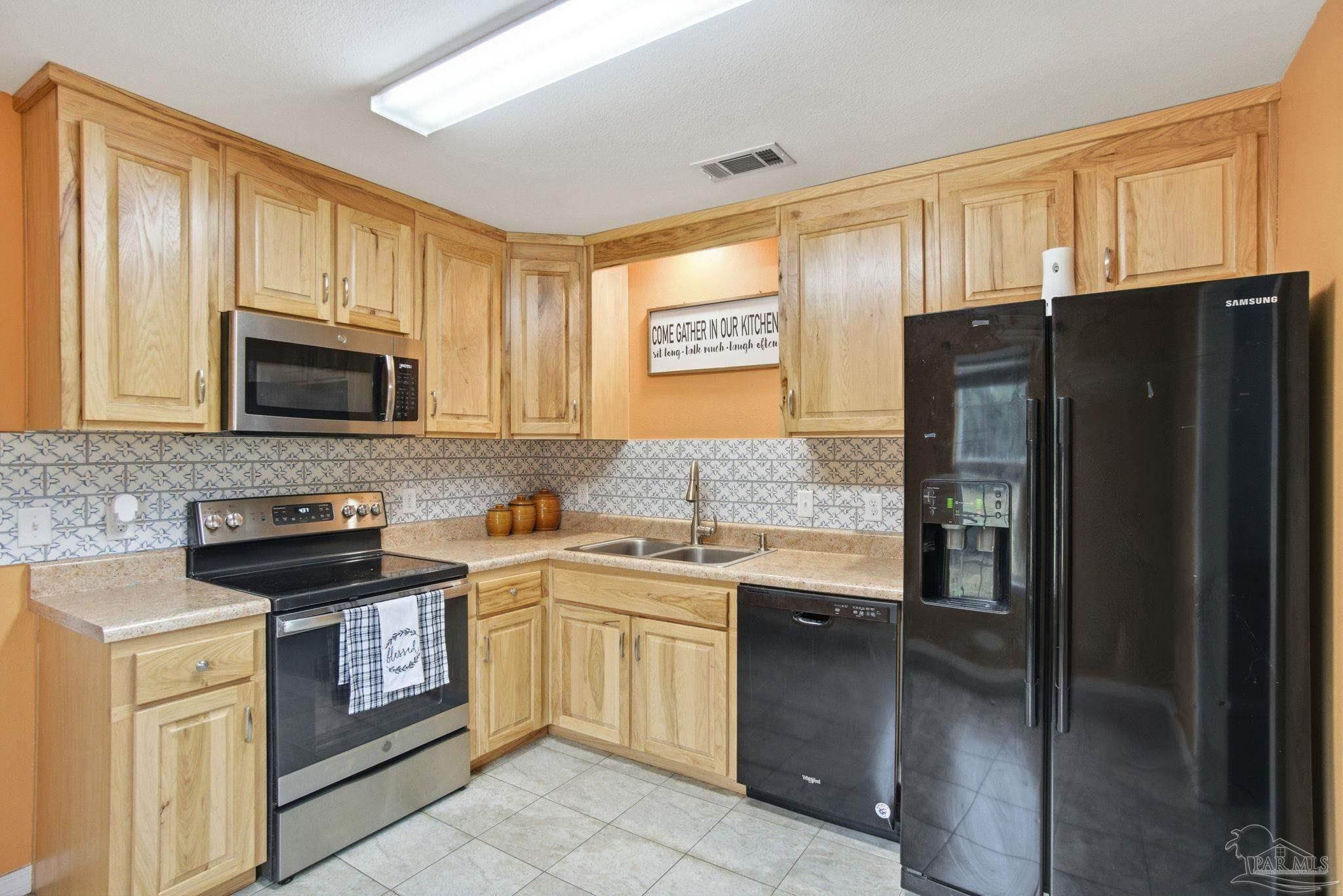 4393 Rice Road Milton, FL 32583 - Photo 12 of 52 a kitchen with stainless steel appliances granite countertop a refrigerator stove and sink