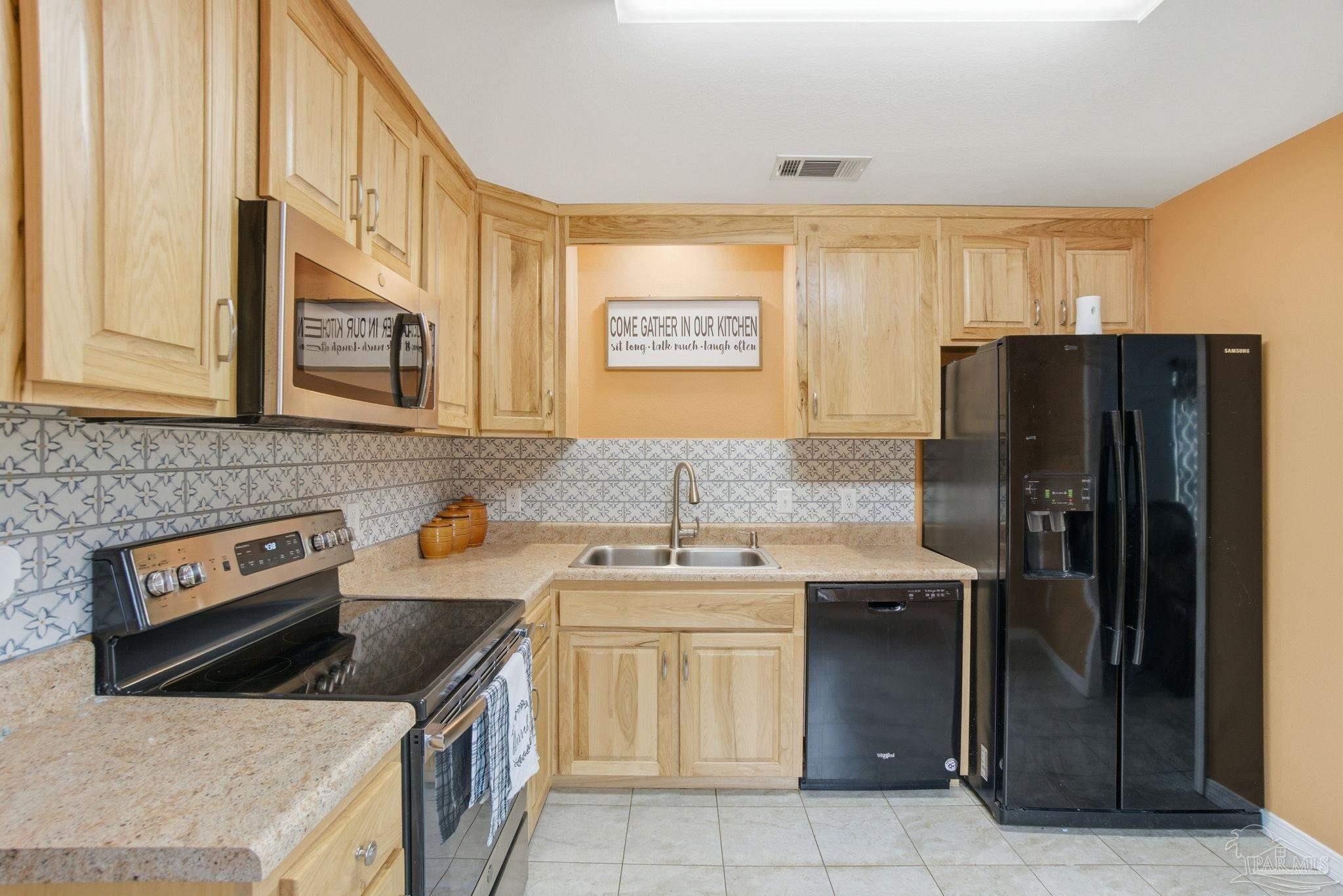 4393 Rice Road Milton, FL 32583 - Photo 13 of 52 a kitchen with stainless steel appliances granite countertop a stove a refrigerator and a sink