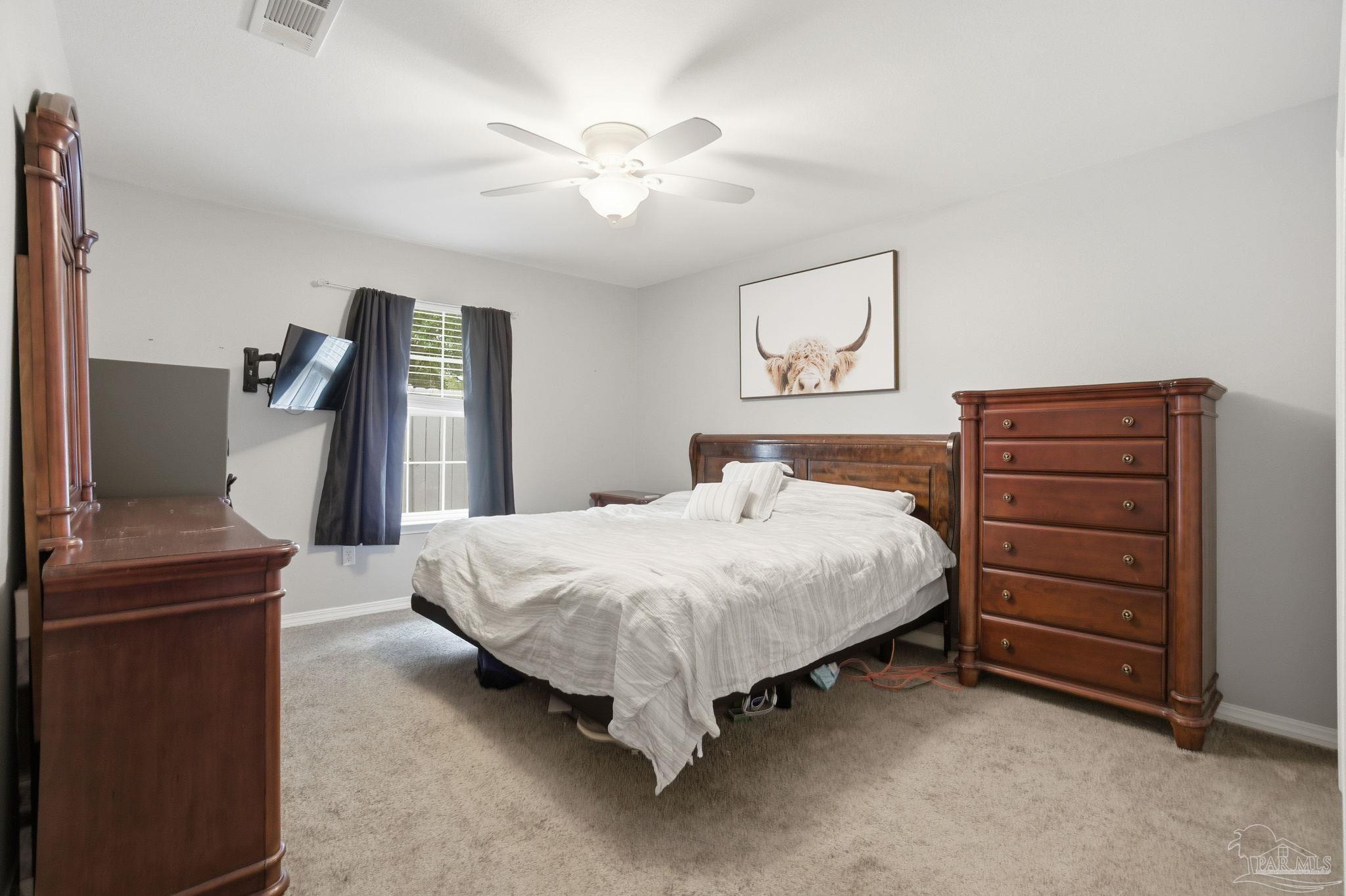 4393 Rice Road Milton, FL 32583 - Photo 16 of 52 a bedroom with a bed and a chandelier