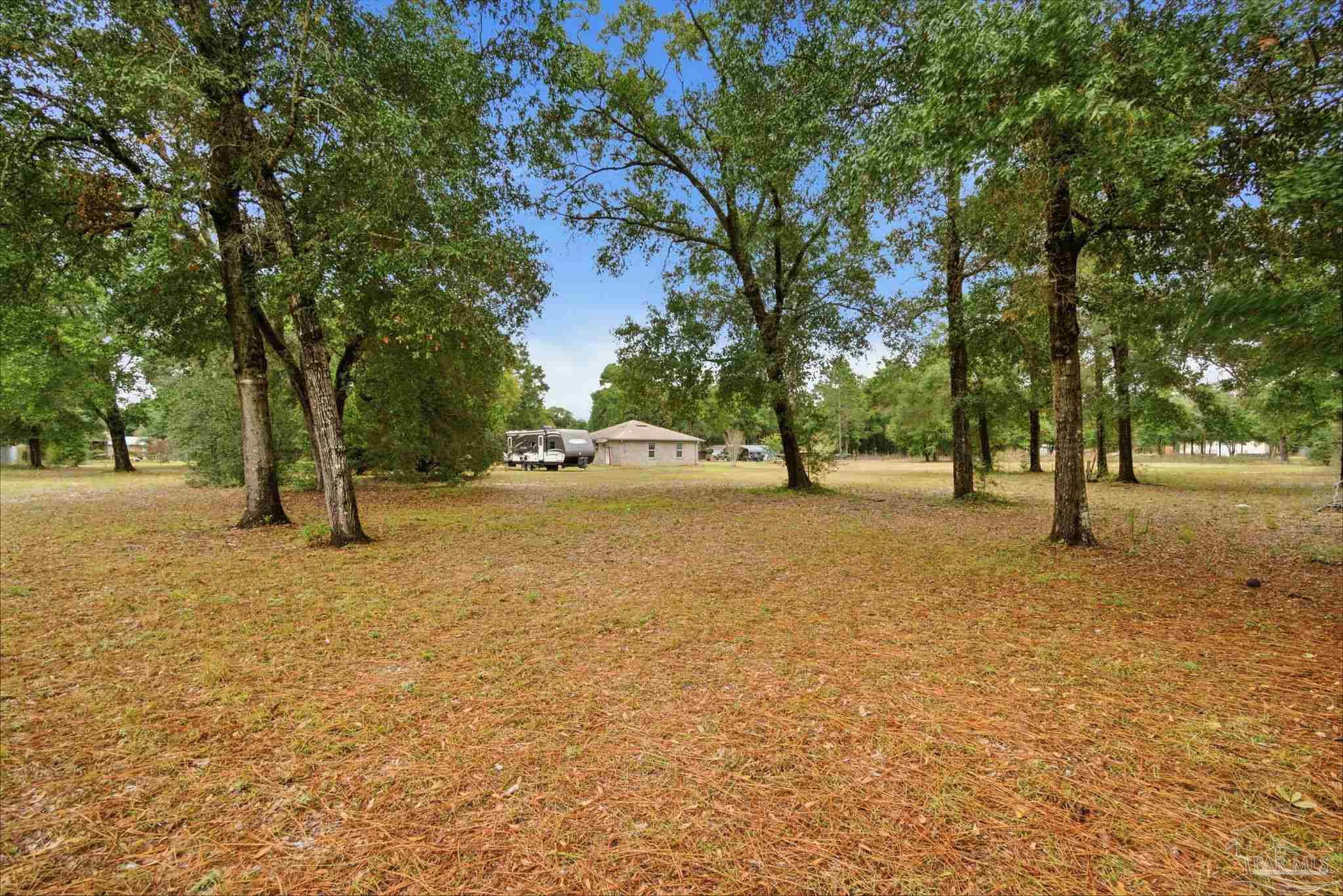 4393 Rice Road Milton, FL 32583 - Photo 26 of 52 a street view with large trees