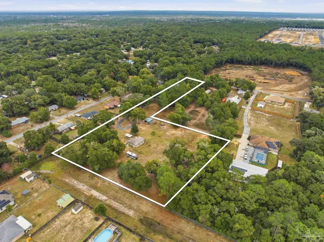an aerial view of residential houses with outdoor space and river