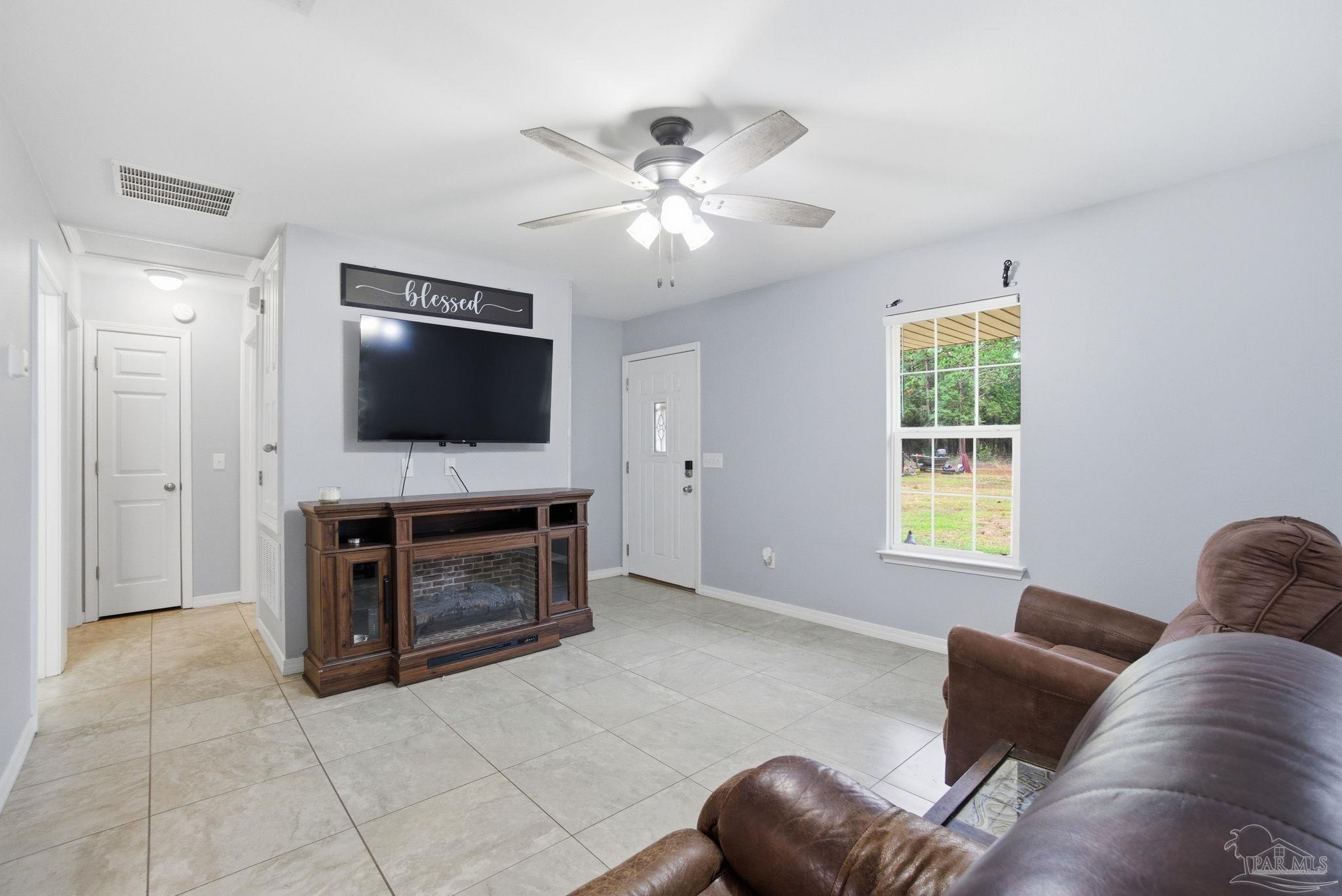 4393 Rice Road Milton, FL 32583 - Photo 9 of 52 a living room with furniture and a flat screen tv