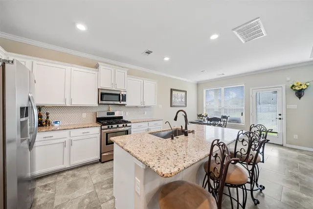 a kitchen with granite countertop a sink stove top oven and cabinets