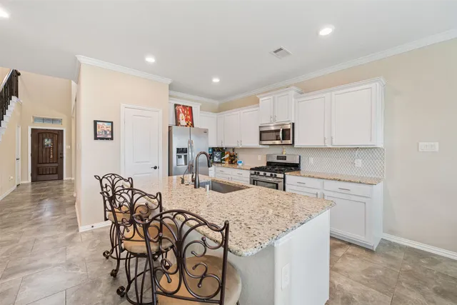 a kitchen with stainless steel appliances granite countertop a stove a microwave and a refrigerator