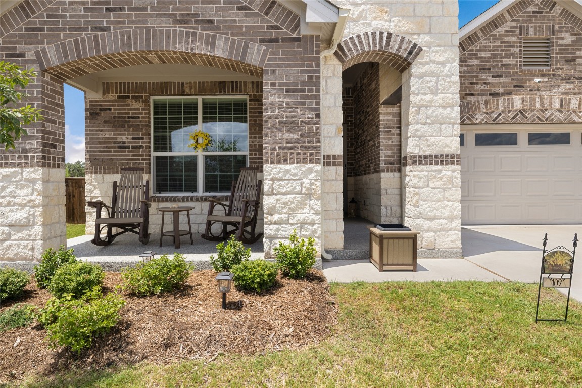 109 Rambling Rapids Drive Georgetown, TX 78628 - Photo 2 of 37 Doorway to property with brick siding, a garage, stone siding, and driveway