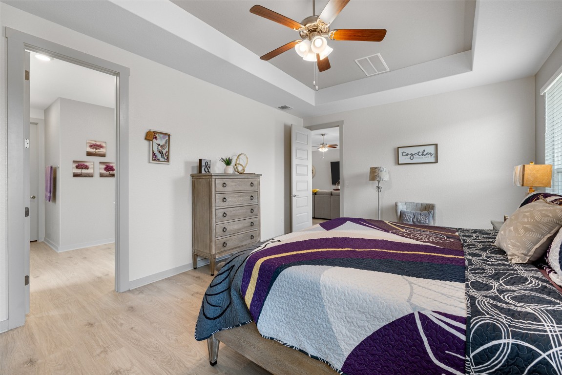 109 Rambling Rapids Drive Georgetown, TX 78628 - Photo 21 of 37 Bedroom with a raised ceiling, wood finished floors, and a ceiling fan