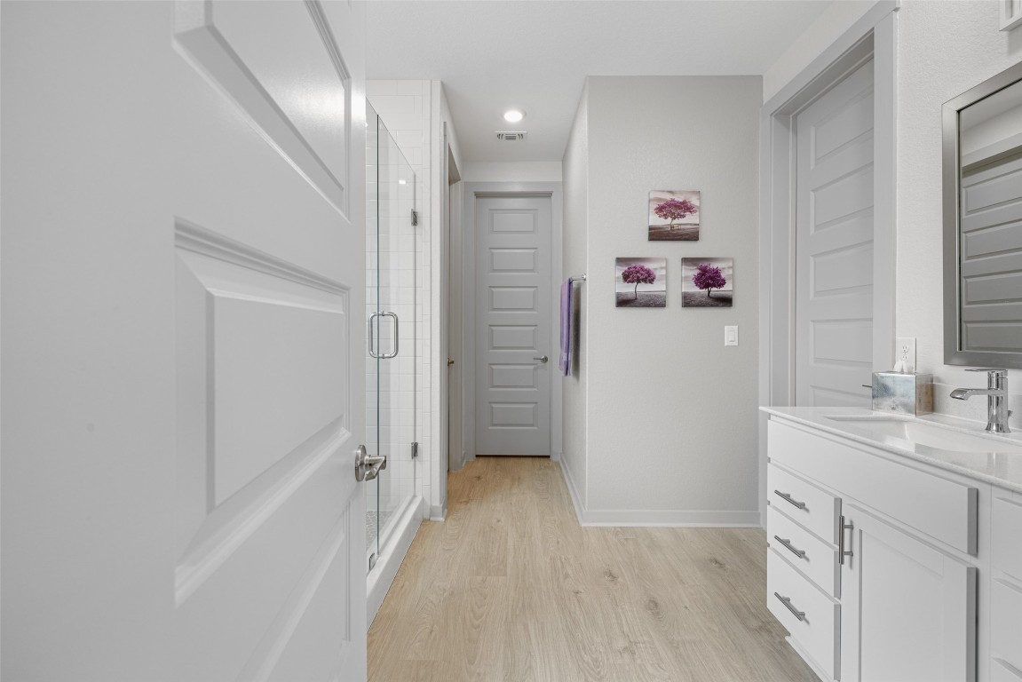 109 Rambling Rapids Drive Georgetown, TX 78628 - Photo 22 of 37 Bathroom with vanity, a stall shower, and light wood-style flooring