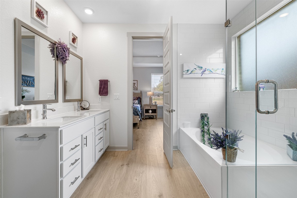 109 Rambling Rapids Drive Georgetown, TX 78628 - Photo 24 of 37 Bathroom featuring healthy amount of natural light, light wood-type flooring, double vanity, and a bath