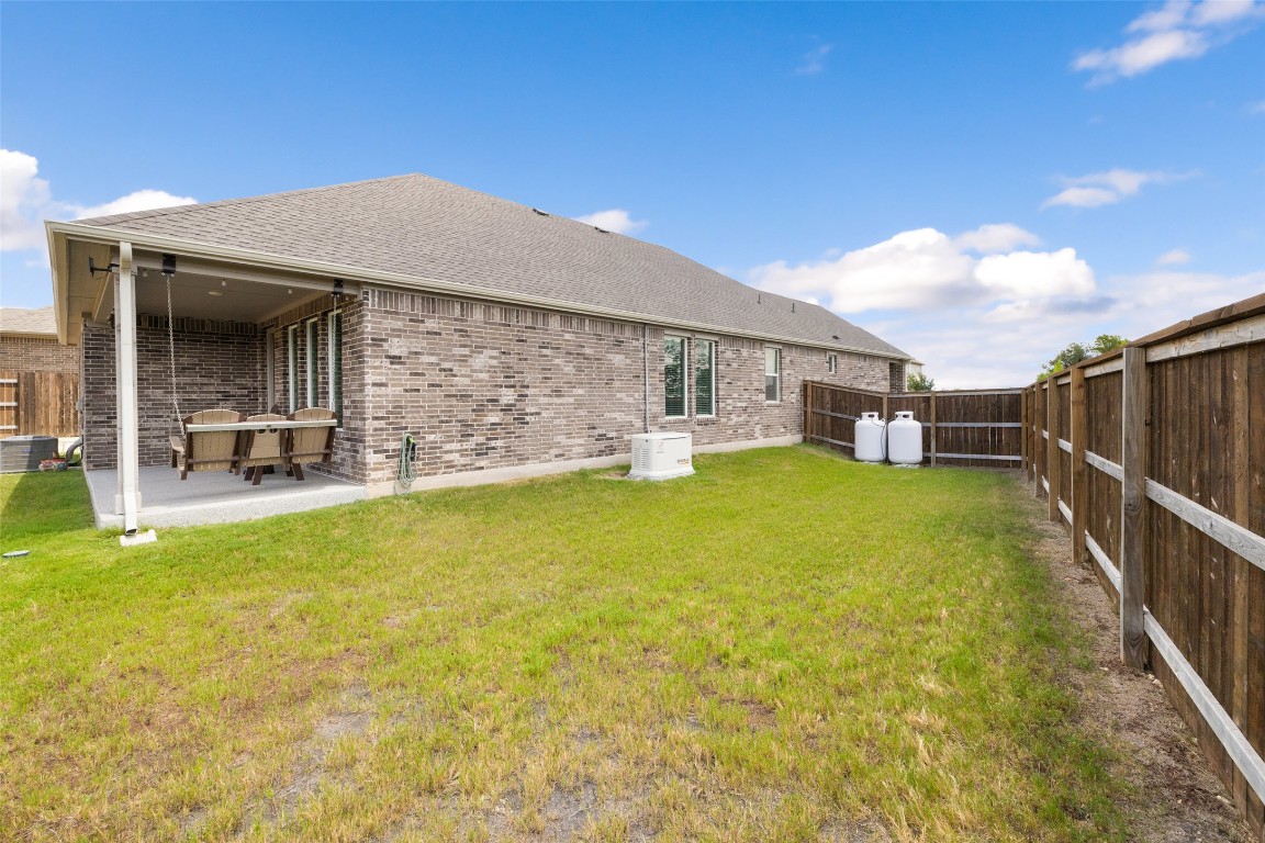 109 Rambling Rapids Drive Georgetown, TX 78628 - Photo 33 of 37 Back of house featuring a fenced backyard, a shingled roof, a patio, and brick siding