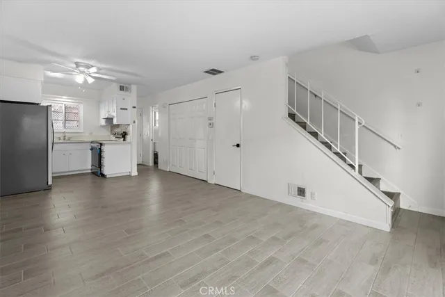 a view of a kitchen with wooden floor and electronic appliances