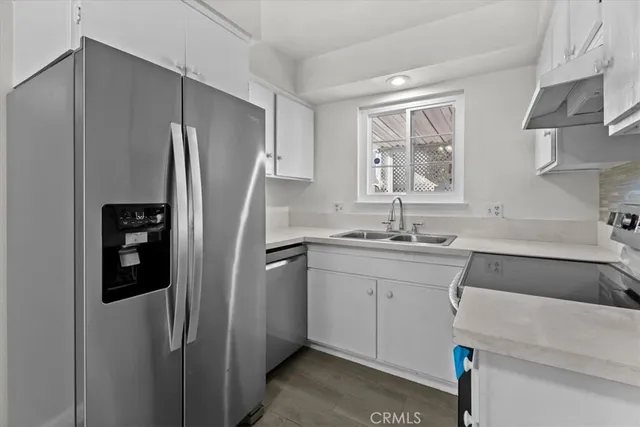 a kitchen with stainless steel appliances granite countertop a refrigerator and a sink