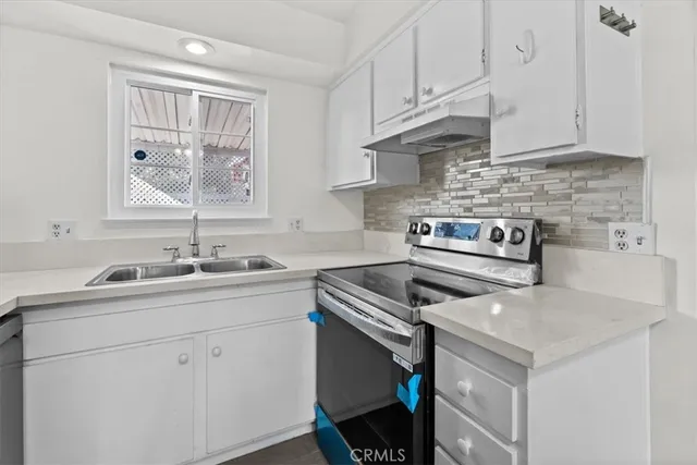 a kitchen with a sink stove and cabinets