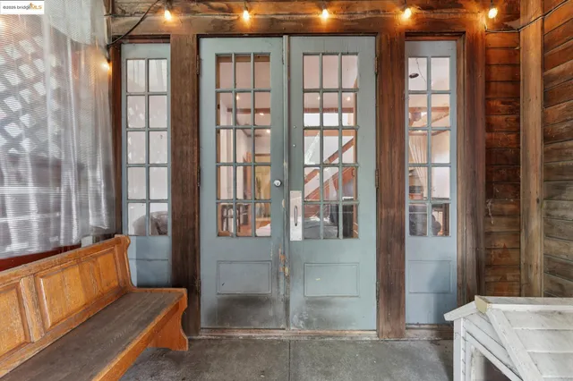 a bedroom with a bed and dresser with wooden floor