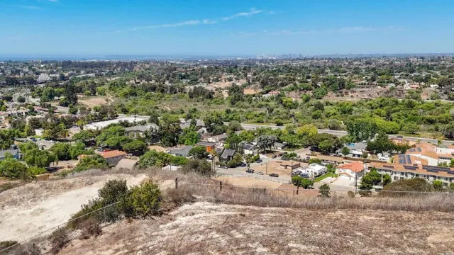 a view of a dry yard with wooden fence