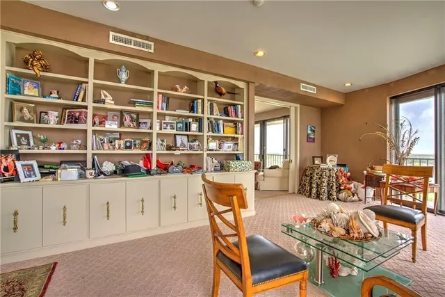 a dining room with stainless steel appliances kitchen island granite countertop a dining table and chairs with wooden floor