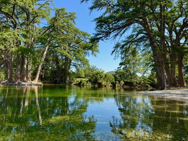 101 Patterson Drive Leakey, TX 78873 - Photo 13 of 18 a view of a lake with a yard and large trees