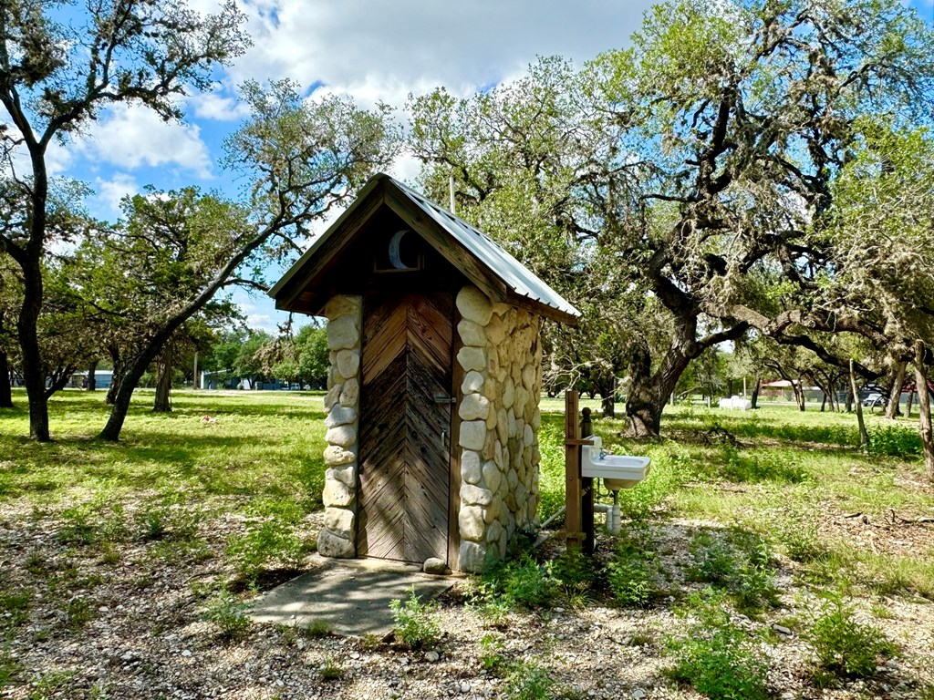 101 Patterson Drive Leakey, TX 78873 - Photo 4 of 18 a view of a wooden house with a big yard and large trees