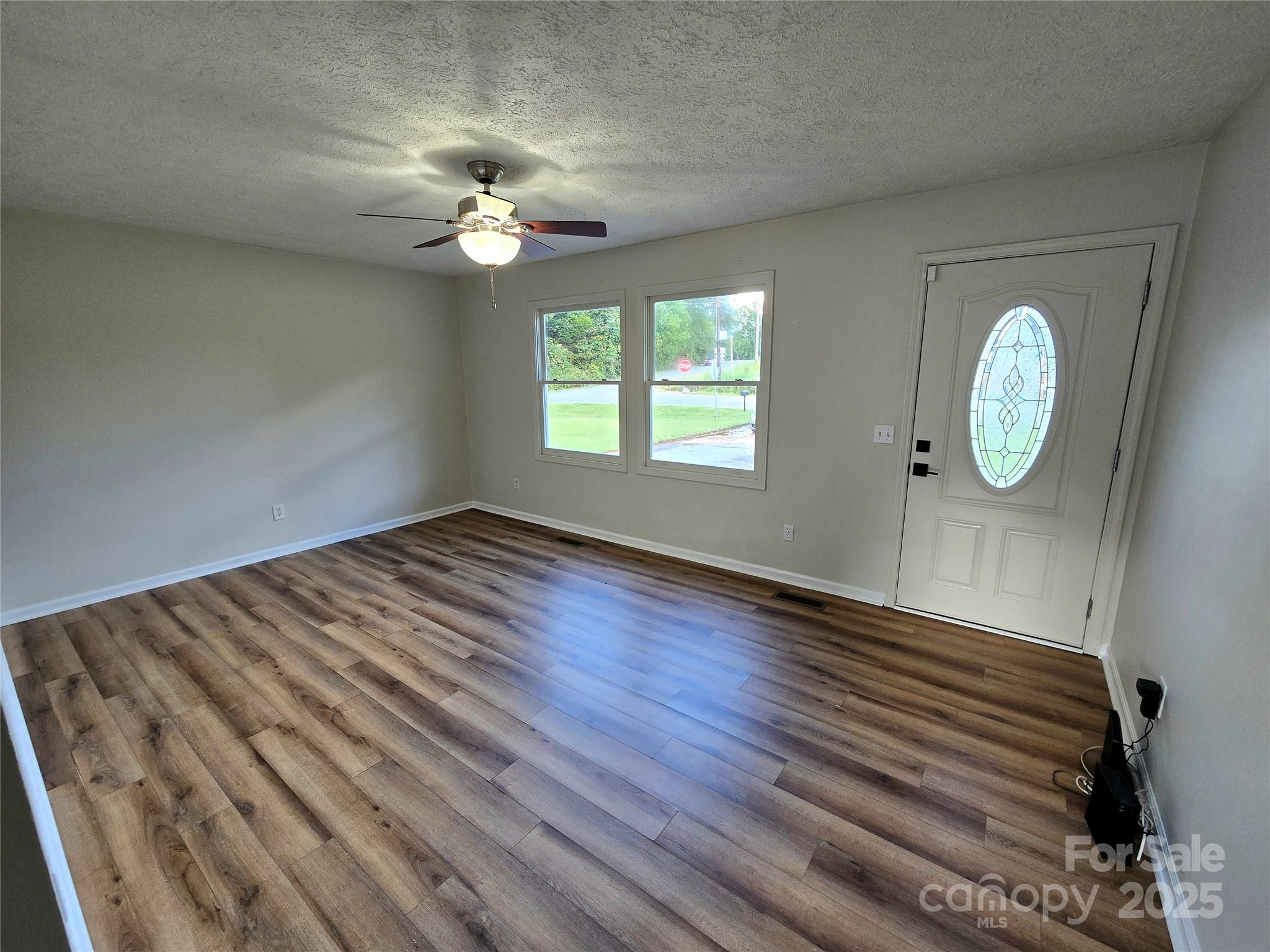 2363 Edna Street Catawba, NC 28609 - Photo 5 of 14 an empty room with wooden floor fan and windows