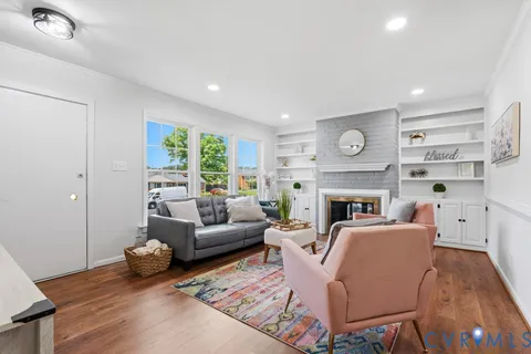 a living room with furniture a fireplace and a large window