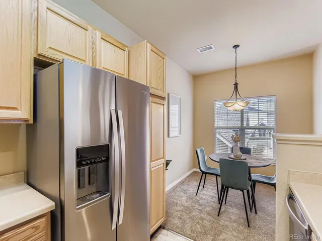 a kitchen with refrigerator a microwave and furniture