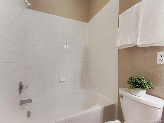 a white bath tub sitting next to a white toilet