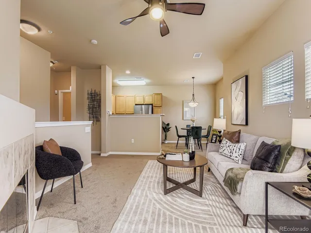 a living room with furniture and a view of kitchen