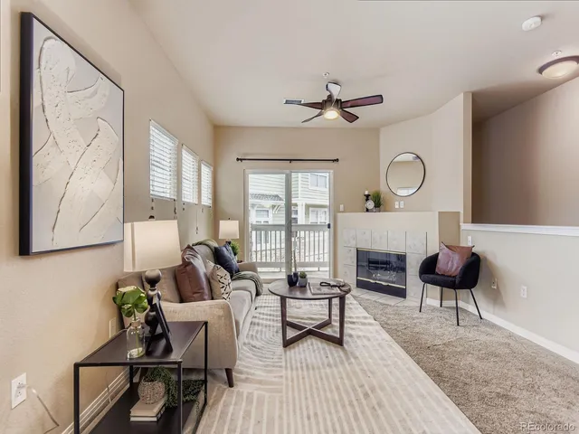 a living room with furniture a fireplace and a large window