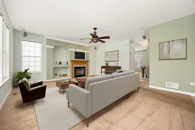 a living room with furniture a fireplace and a chandelier
