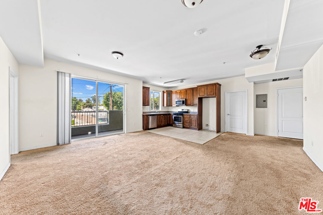 7122 Amigo Avenue Reseda, CA 91335 - Photo 4 of 16 a view of an empty room with a fireplace and a window
