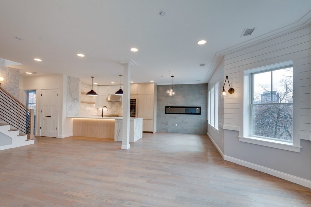 15 Euston Street, Unit 3 Brookline, MA 02446 - Photo 14 of 37 a view of a kitchen with kitchen island wooden floors wooden cabinets and windows
