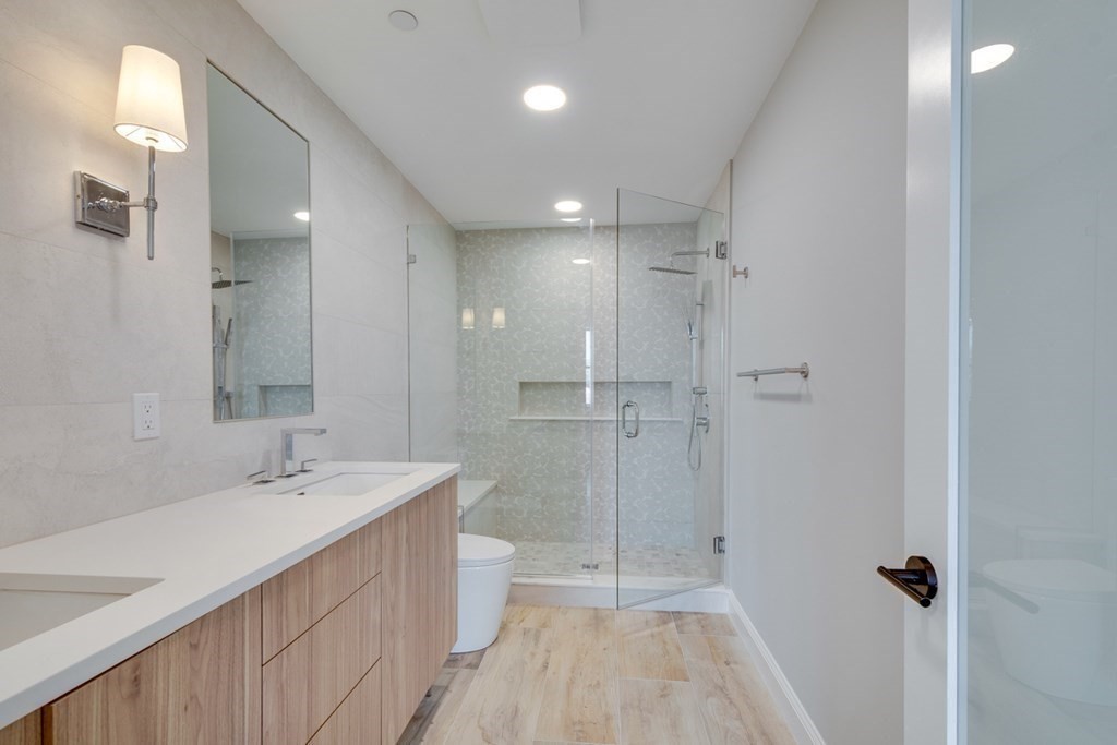 15 Euston Street, Unit 3 Brookline, MA 02446 - Photo 27 of 37 a bathroom with a double vanity sink a mirror and a shower
