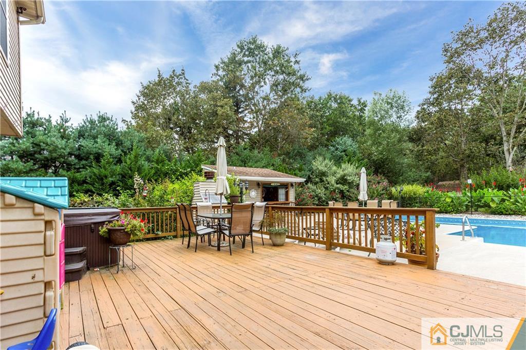 7 Country Road Jackson, NJ 08527 - Photo 41 of 44 a view of a roof deck with table and chairs a barbeque with wooden floor and fence