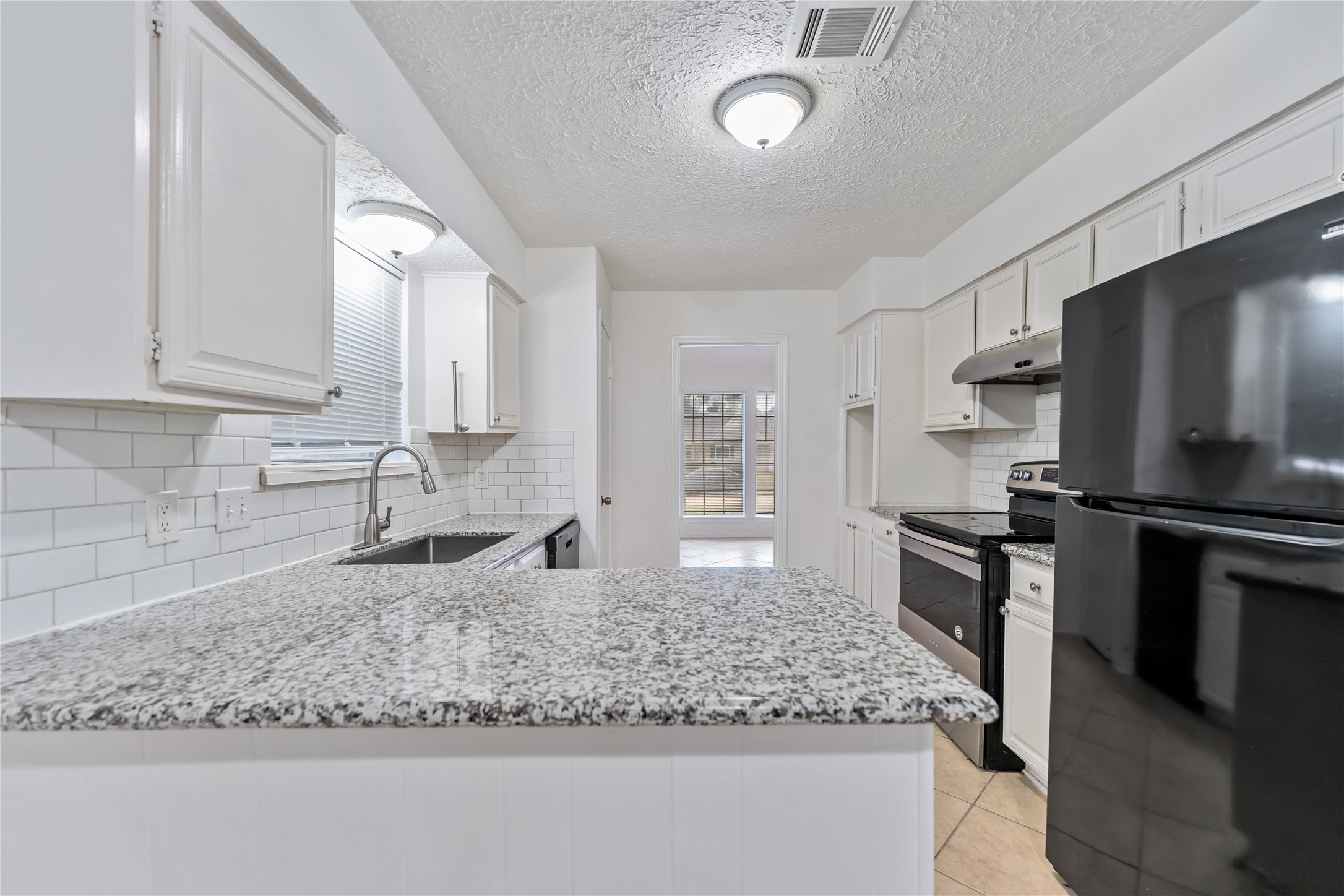4927 Glendower Drive Spring, TX 77373 - Photo 6 of 22 a kitchen with stainless steel appliances granite countertop a sink stove and refrigerator