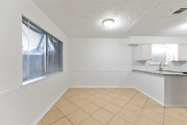 a bathroom with a granite countertop sink and a bathtub