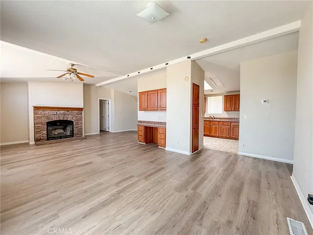a view of empty room with a fireplace and wooden floor