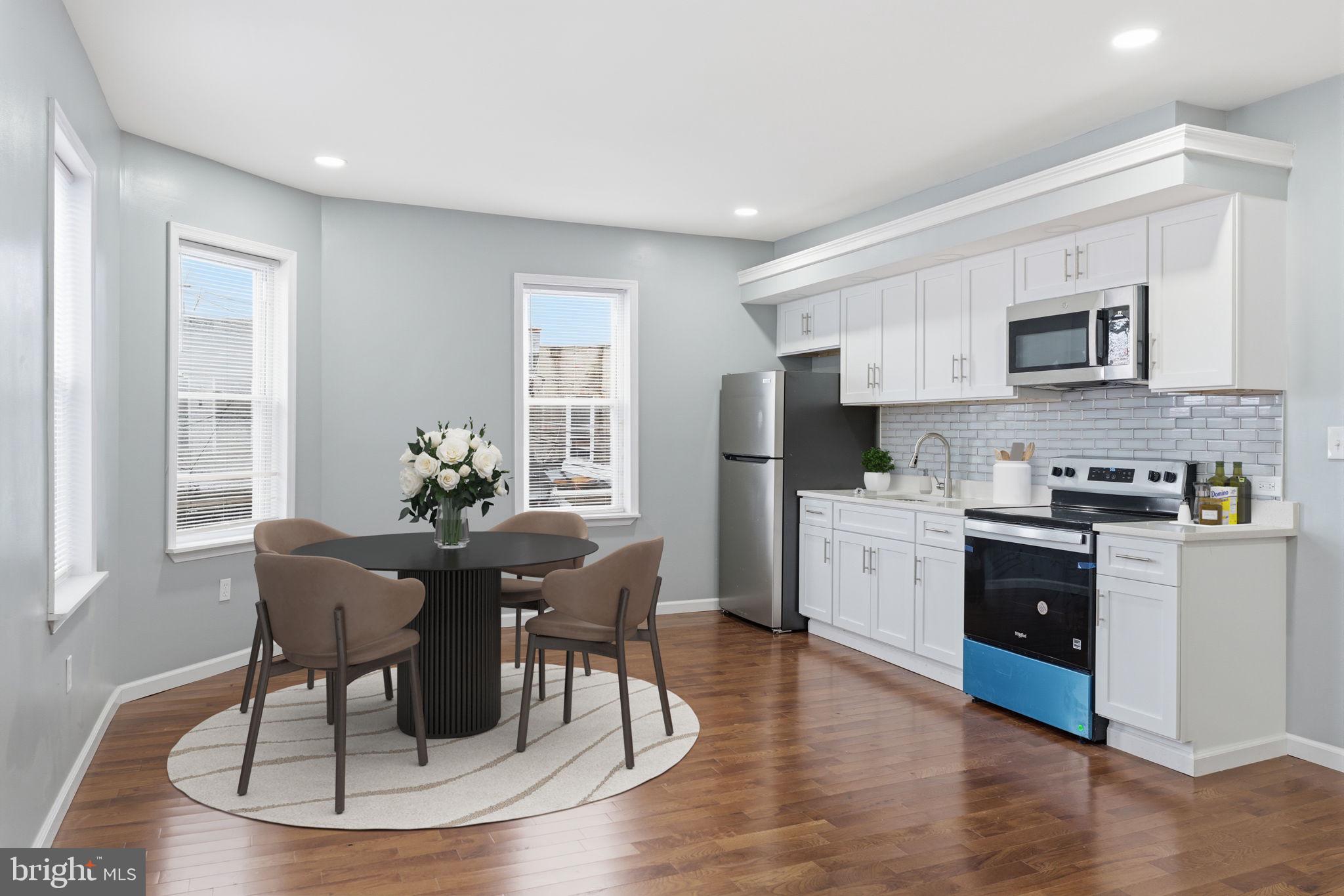 3128 F Street Philadelphia, PA 19134 - Photo 17 of 30 a kitchen with stainless steel appliances granite countertop a stove a sink a microwave a dining table and chairs