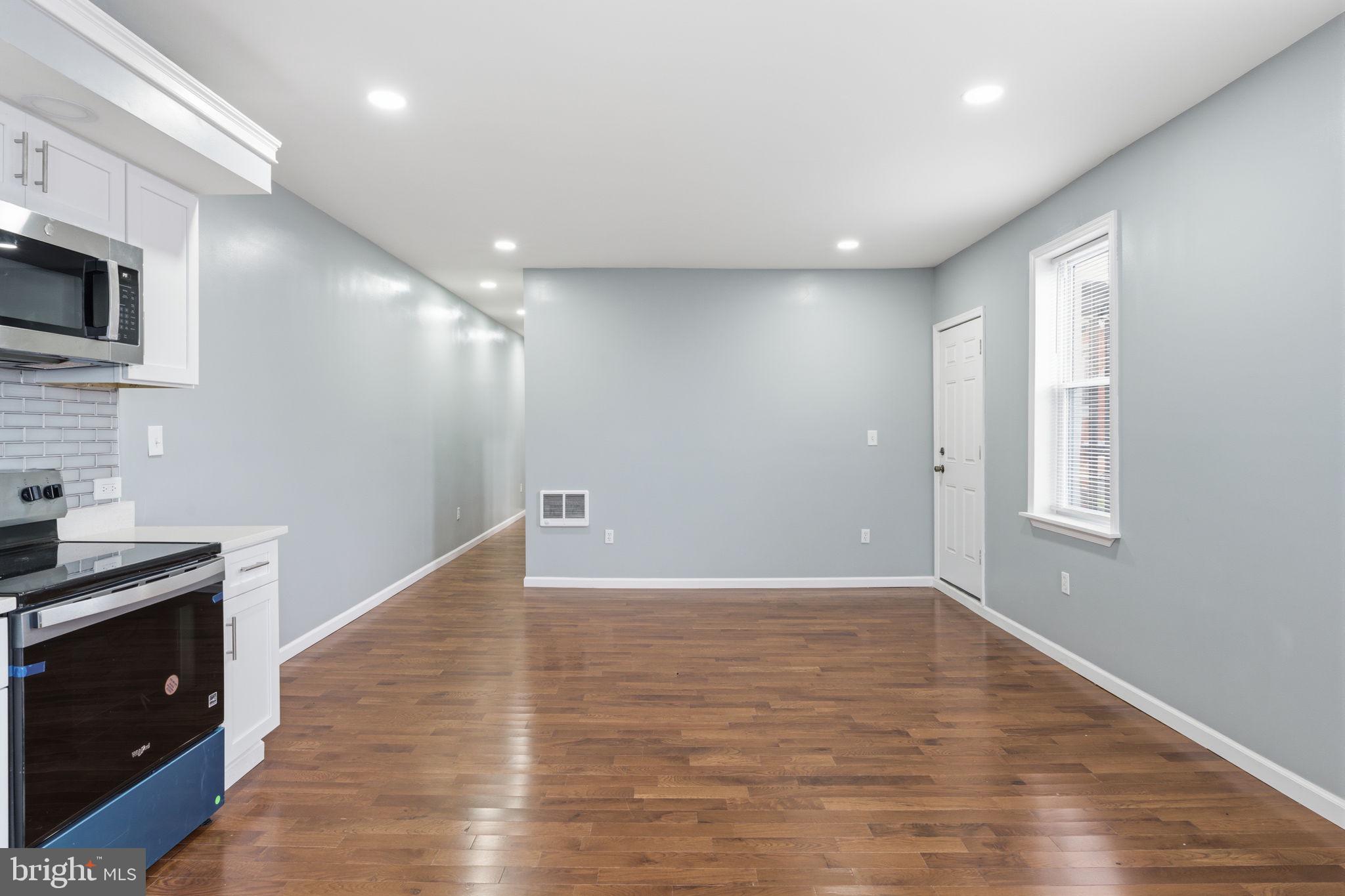 3128 F Street Philadelphia, PA 19134 - Photo 21 of 30 a view of an empty room with wooden floor and a kitchen