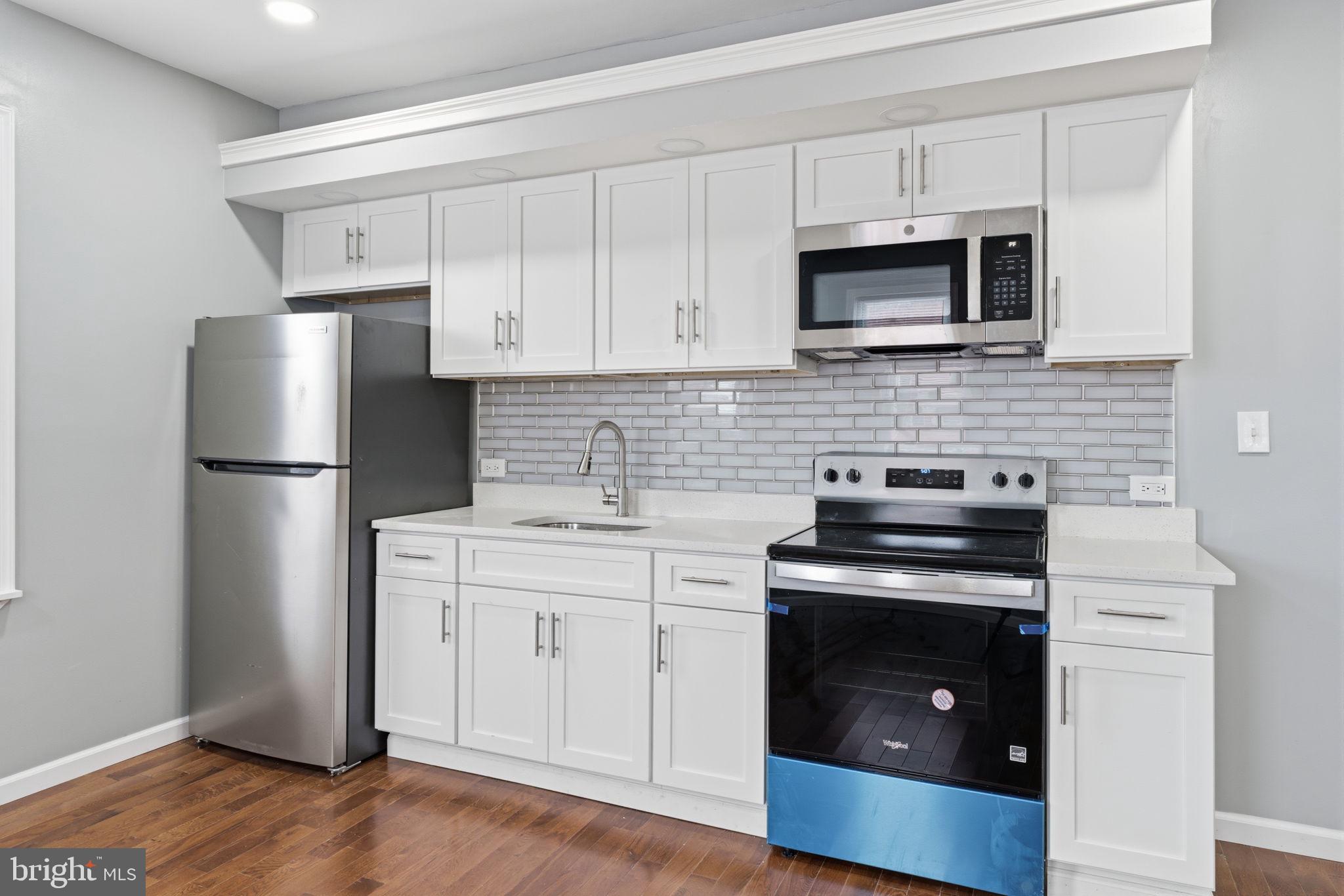3128 F Street Philadelphia, PA 19134 - Photo 22 of 30 a kitchen with a stove microwave and refrigerator