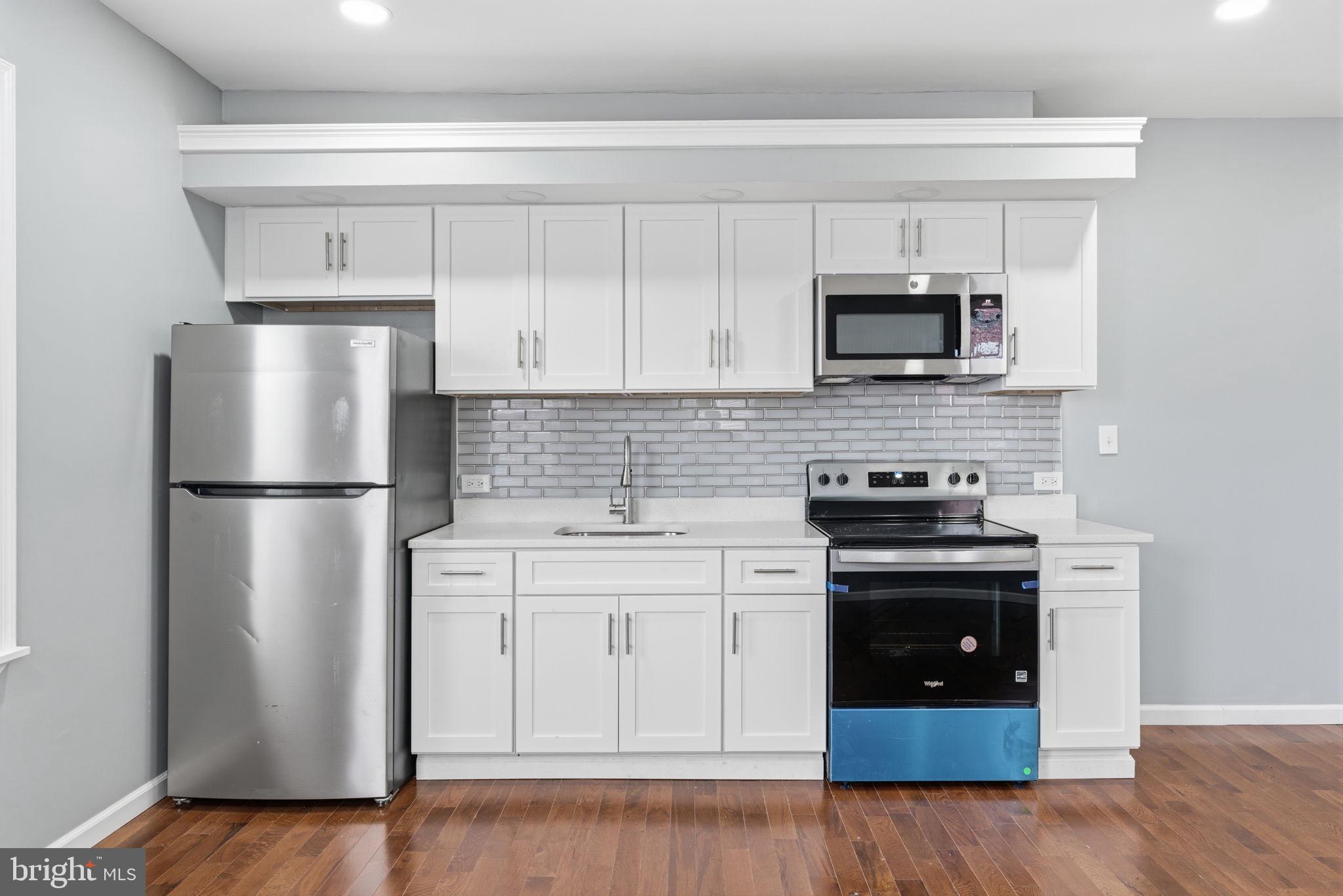 3128 F Street Philadelphia, PA 19134 - Photo 23 of 30 a kitchen with white cabinets and stainless steel appliances