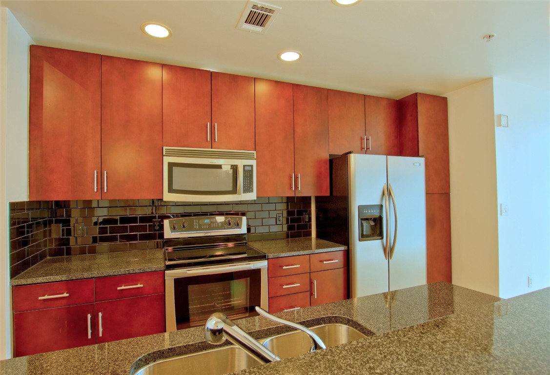 360 Nueces Street, Unit 913 Austin, TX 78701 - Photo 2 of 30 a kitchen with stainless steel appliances granite countertop a stove a refrigerator and a microwave