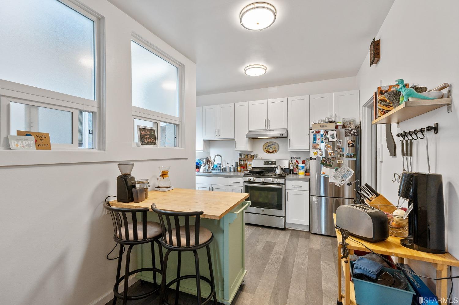 439-441 11th Avenue San Francisco, CA 94118 - Photo 43 of 73 a kitchen with a table chairs and a refrigerator