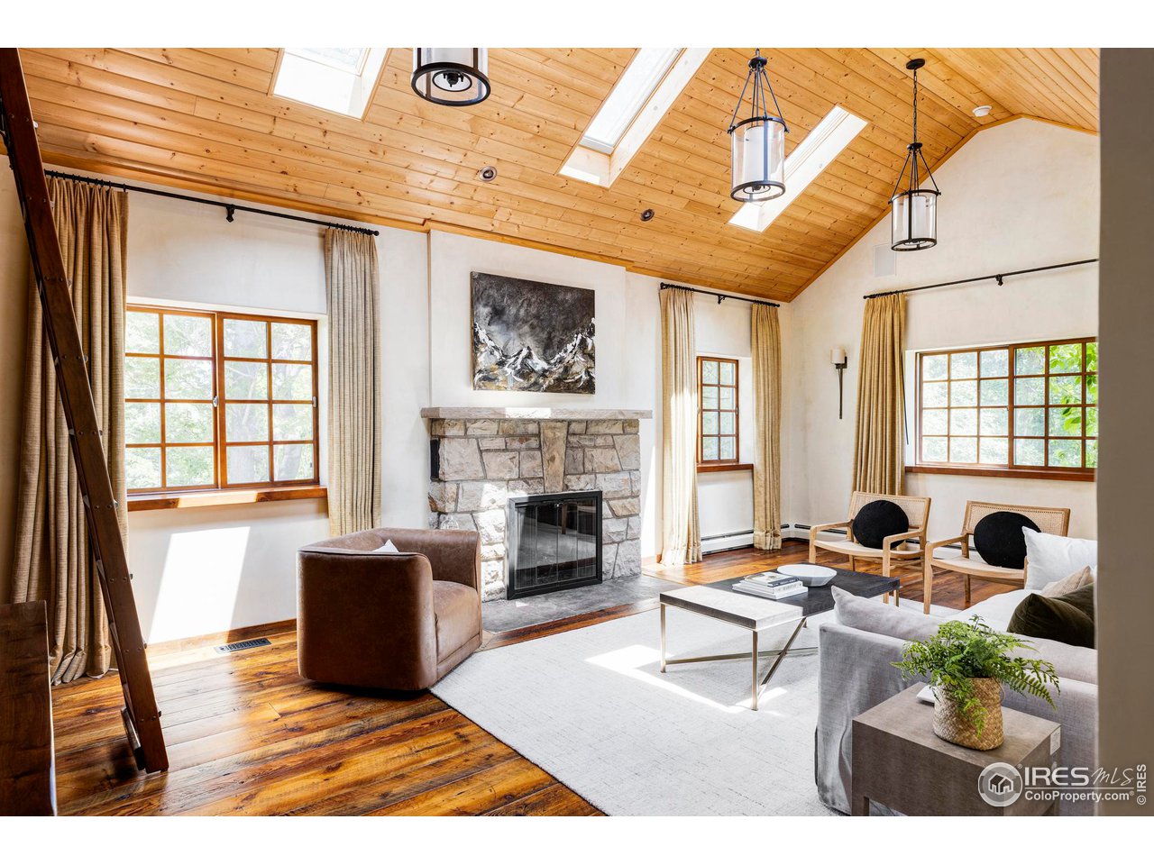 1213 17th Street Boulder, CO 80302 - Photo 12 of 38 a living room with furniture a fireplace and a floor to ceiling window