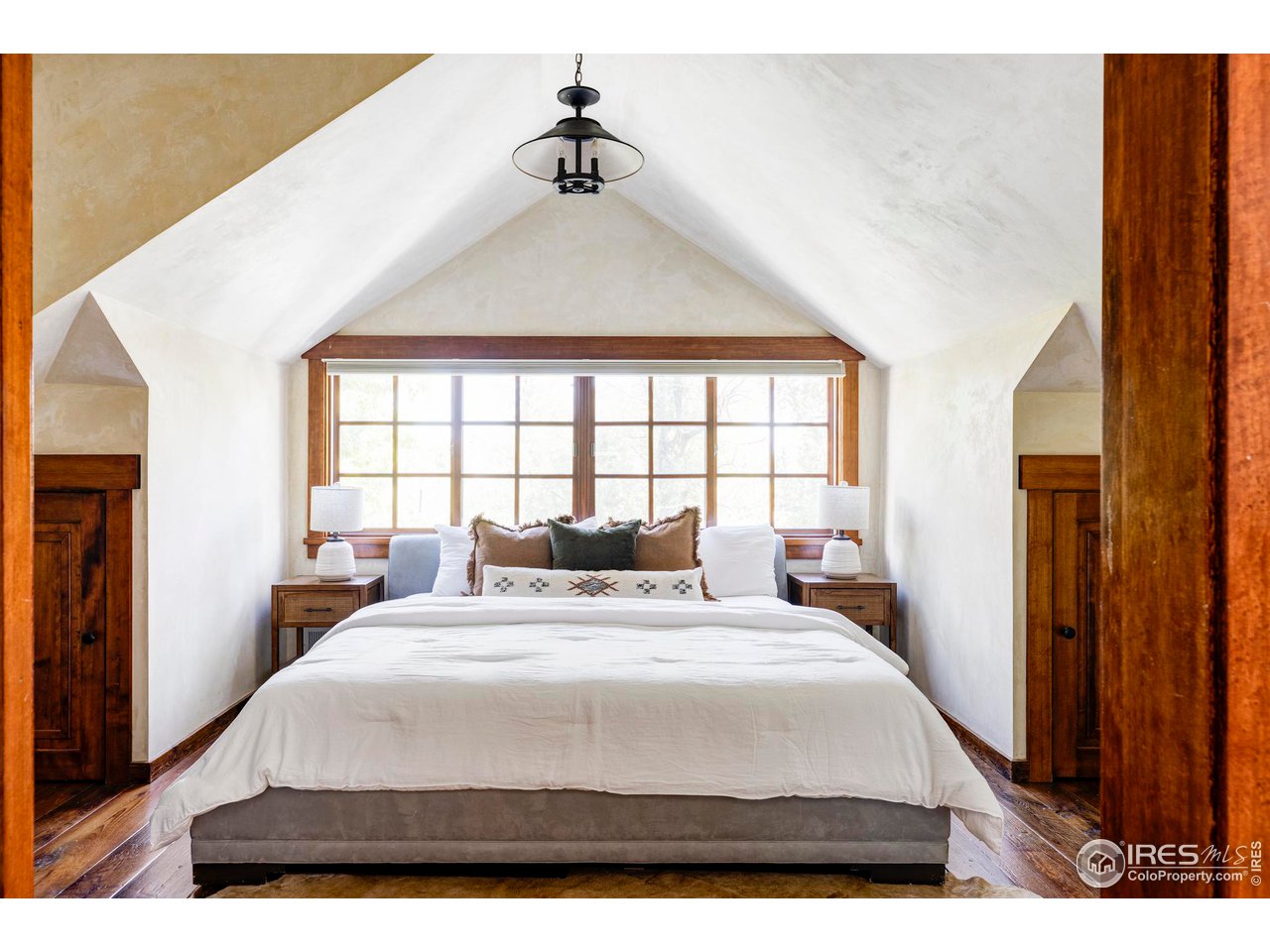 1213 17th Street Boulder, CO 80302 - Photo 19 of 38 a bedroom with a large bed and a chandelier