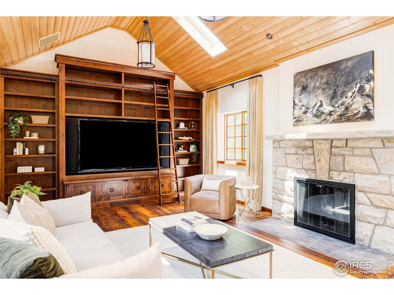1213 17th Street Boulder, CO 80302 - Photo 3 of 38 a living room with furniture a flat screen tv and a fireplace
