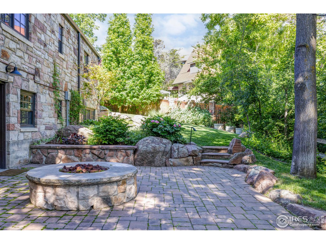 1213 17th Street Boulder, CO 80302 - Photo 32 of 38 a view of a backyard with table and chairs potted plants and large tree