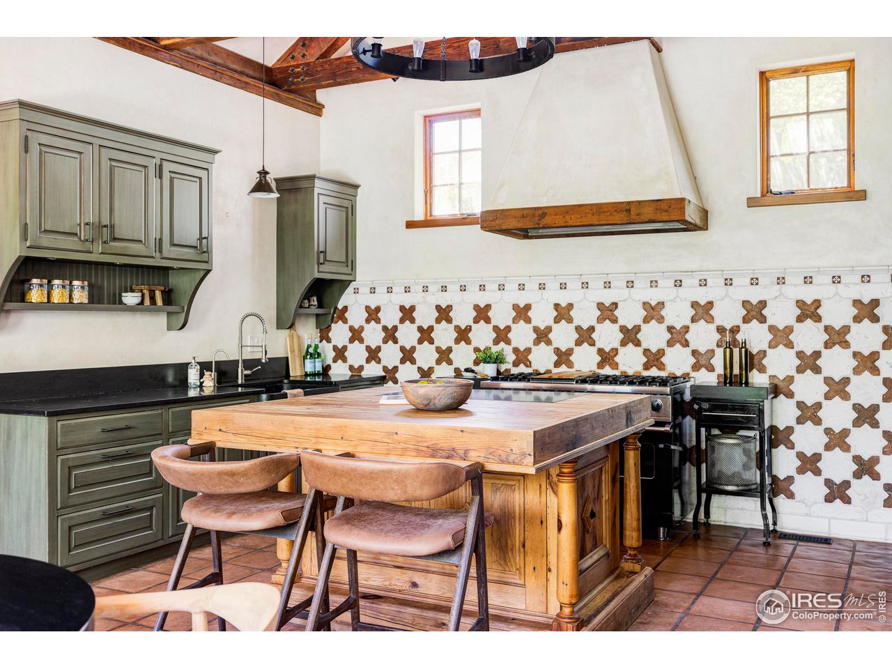 1213 17th Street Boulder, CO 80302 - Photo 7 of 38 a kitchen with stainless steel appliances kitchen island granite countertop a table chairs and a refrigerator