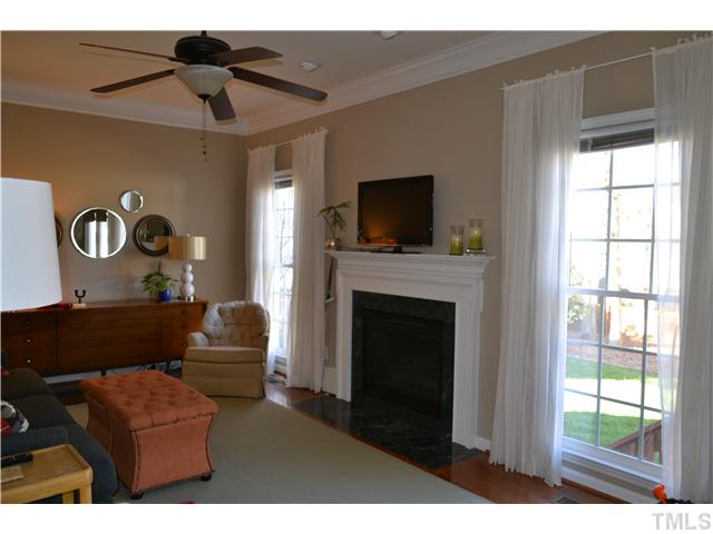 6937 Lamarsh Court Raleigh, NC 27617 - Photo 3 of 25 a living room with furniture a flat screen tv and a fireplace