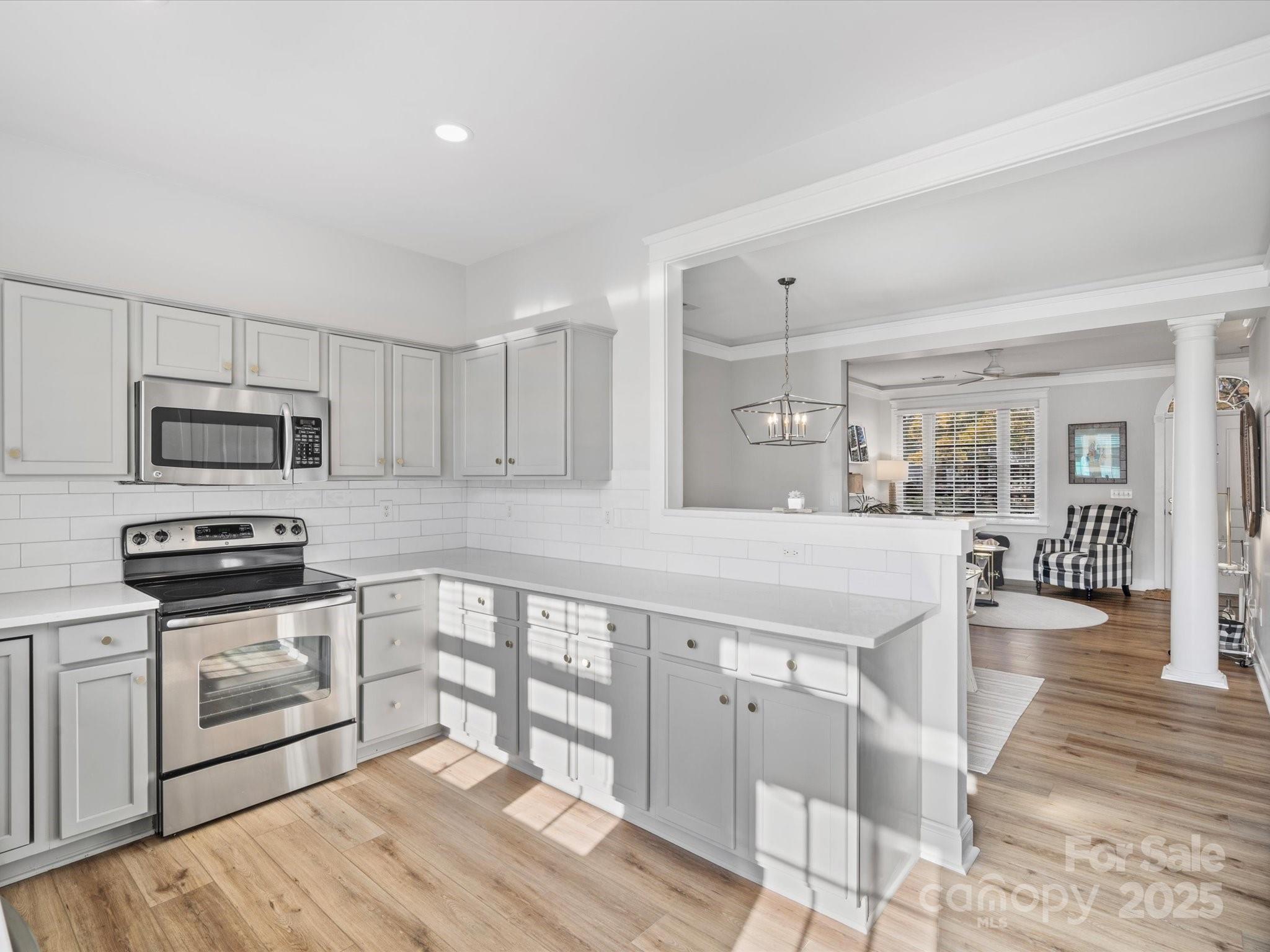 296 Elis Way Fort Mill, SC 29708 - Photo 9 of 31 a kitchen with stainless steel appliances granite countertop a stove top oven a sink dishwasher and white cabinets with wooden floor