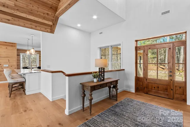 a living room with furniture a rug potted plant and windows